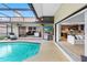 Stunning pool area offering a seamless indoor/outdoor living experience with a barbecue and access to kitchen at 12470 93Rd St, Largo, FL 33773