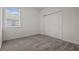 Cozy bedroom with plush carpeting, a large window for natural light, and a closet with sliding doors at 12697 Achasta Blvd, Hudson, FL 34669
