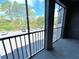 Balcony with a railing overlooking a picturesque view of the lake, greenery, and parking area at 13235 Sanctuary Cove Dr # 201, Temple Terrace, FL 33637
