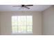 Bedroom featuring a large window that provides a view of the surrounding landscape and a ceiling fan at 13235 Sanctuary Cove Dr # 201, Temple Terrace, FL 33637
