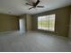 A spacious living room with tile floors, ceiling fan, access to a balcony, and a window for natural light at 13235 Sanctuary Cove Dr # 201, Temple Terrace, FL 33637