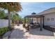 Backyard paver patio with a pergola covered table, seating, and lush tropical landscaping at 14711 Potterton Cir, Hudson, FL 34667