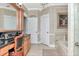 Bright bathroom featuring a jetted tub, double doors, and neutral wall color at 14711 Potterton Cir, Hudson, FL 34667