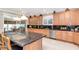 Modern kitchen featuring wood cabinets, island seating, and granite countertops at 14711 Potterton Cir, Hudson, FL 34667