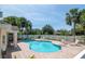 Beautiful community pool with lounge chairs, brick patio, and white picket fence, surrounded by mature trees and landscaping at 14711 Potterton Cir, Hudson, FL 34667