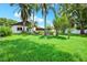 Landscaped backyard with lush green grass, trees, and view of the property at 15108 Springview St, Tampa, FL 33624