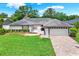 Inviting one-story home with well-maintained landscaping, lush lawn, and brick driveway leading to the garage at 15108 Springview St, Tampa, FL 33624