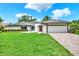 Charming single-story home with a lush green lawn and a brick driveway leading to a two-car garage at 15108 Springview St, Tampa, FL 33624