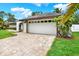 Spacious two-car garage with a brick driveway, set against a well-manicured lawn and mature landscaping at 15108 Springview St, Tampa, FL 33624