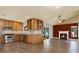 Open kitchen with stainless steel appliances, wood cabinets, and breakfast bar flowing into a living area with a fireplace at 15108 Springview St, Tampa, FL 33624
