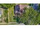 Aerial view of a home with solar panels, surrounded by mature trees and a fenced yard at 1517 Gunsmith Dr, Lutz, FL 33559