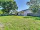 Fenced backyard featuring a lush lawn, the home's rear, and mature trees at 1517 Gunsmith Dr, Lutz, FL 33559
