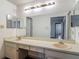 Bright bathroom featuring double sinks, a vanity and large mirror at 1517 Gunsmith Dr, Lutz, FL 33559