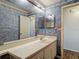 Bathroom featuring a large mirror and sink, with blue patterned wallpaper at 1517 Gunsmith Dr, Lutz, FL 33559