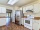 Bright kitchen with stainless steel refrigerator, white cabinets, and open access to the living room at 1517 Gunsmith Dr, Lutz, FL 33559