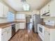 Open kitchen featuring white cabinets, stainless appliances, and views into the living area at 1517 Gunsmith Dr, Lutz, FL 33559