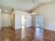 Open-concept living room with wood floors, chandelier, and a glimpse into the adjacent kitchen at 1517 Gunsmith Dr, Lutz, FL 33559
