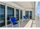Outdoor balcony with tile flooring, two blue chairs, and a small table with ocean views at 1586 Gulf Blvd # 2502, Clearwater, FL 33767