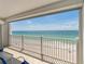 Balcony overlooking a white sand beach and clear blue-green ocean under a sunny sky at 1586 Gulf Blvd # 2502, Clearwater, FL 33767