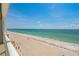 Serene beach view showcases white sand, clear turquoise water, and cloudless blue sky at 1586 Gulf Blvd # 2502, Clearwater, FL 33767