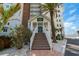 Condominium building entrance with stairs, landscaping, and signage near the ocean at 1586 Gulf Blvd # 2502, Clearwater, FL 33767