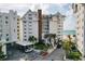 Beautiful beachside condo with a charming white facade, lush landscaping, and convenient covered parking at 1586 Gulf Blvd # 2502, Clearwater, FL 33767