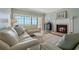 Cozy living room featuring a fireplace, comfortable seating, and sliding glass doors to a balcony with ocean views at 1586 Gulf Blvd # 2502, Clearwater, FL 33767