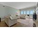 Bright living room with hardwood floors, comfortable furniture, and sliding glass doors to a balcony with ocean views at 1586 Gulf Blvd # 2502, Clearwater, FL 33767