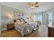 Comfortable main bedroom with a ceiling fan, and sliding glass doors to a balcony with ocean views at 1586 Gulf Blvd # 2502, Clearwater, FL 33767