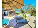 Outdoor living space with pool, outdoor kitchen, lounge area, and lush landscaping at 1608 20Th W Ave, Palmetto, FL 34221