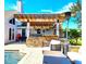 Backyard features a pool, stone patio, outdoor kitchen and covered seating area at 1608 20Th W Ave, Palmetto, FL 34221