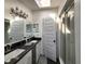 Bathroom featuring double sinks, dark countertops, vanity lighting, and a walk-in shower at 1608 20Th W Ave, Palmetto, FL 34221