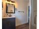 Bathroom vanity with dark blue cabinets, black hardware, and views of the shower at 1608 20Th W Ave, Palmetto, FL 34221