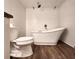 Bathroom featuring a modern soaking tub and toilet against white textured tile walls at 1608 20Th W Ave, Palmetto, FL 34221