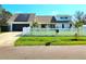 Welcoming home with white picket fence, green lawn, solar panels, and charming curb appeal at 1608 20Th W Ave, Palmetto, FL 34221