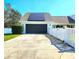View of the two-car garage and driveway, complete with solar panels and a white picket fence at 1608 20Th W Ave, Palmetto, FL 34221