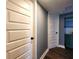 Hallway with wood-look floors, blue accent wall, and white doors at 1608 20Th W Ave, Palmetto, FL 34221