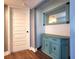 Hallway features wood-look floors, a decorative cabinet, and mirror with blue accent at 1608 20Th W Ave, Palmetto, FL 34221
