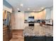 Modern kitchen with stainless steel refrigerator, granite island, and white cabinets offering ample storage at 1608 20Th W Ave, Palmetto, FL 34221