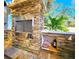Close up of an outdoor fireplace that features a stone surround and adjacent shelving at 1608 20Th W Ave, Palmetto, FL 34221