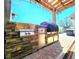 Outdoor kitchen featuring stainless steel grill, stone surround and concrete paver patio at 1608 20Th W Ave, Palmetto, FL 34221