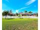 Lush front yard featuring a white picket fence and green lawn, with views of the neighborhood homes beyond at 1608 20Th W Ave, Palmetto, FL 34221
