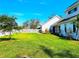 Spacious side yard with lush green lawn, white picket fence, and partial view of a bright white home at 1608 20Th W Ave, Palmetto, FL 34221
