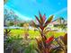 Professionally landscaped front yard with colorful flowers, green lawn, white fence and view of the neighborhood at 1608 20Th W Ave, Palmetto, FL 34221