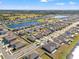 Aerial view of a residential community, showcasing a scenic pond and neatly arranged homes in a suburban setting at 16632 Sunburst Lake St, Wimauma, FL 33598