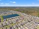 Aerial view of a neighborhood featuring a pond, green spaces, and neatly arranged single-Gathering homes at 16632 Sunburst Lake St, Wimauma, FL 33598