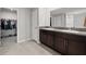 Bathroom with double sinks, granite countertops, and walk-in closet at 16632 Sunburst Lake St, Wimauma, FL 33598