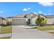 Charming single-story home with a well-manicured lawn and a two-car garage and lush landscaping at 16632 Sunburst Lake St, Wimauma, FL 33598
