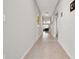 Long hallway featuring tile flooring and neutral paint, connecting various living spaces within the home at 16632 Sunburst Lake St, Wimauma, FL 33598