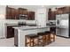 Modern kitchen with dark cabinets, granite countertops, stainless steel appliances, and a large island with seating at 16632 Sunburst Lake St, Wimauma, FL 33598